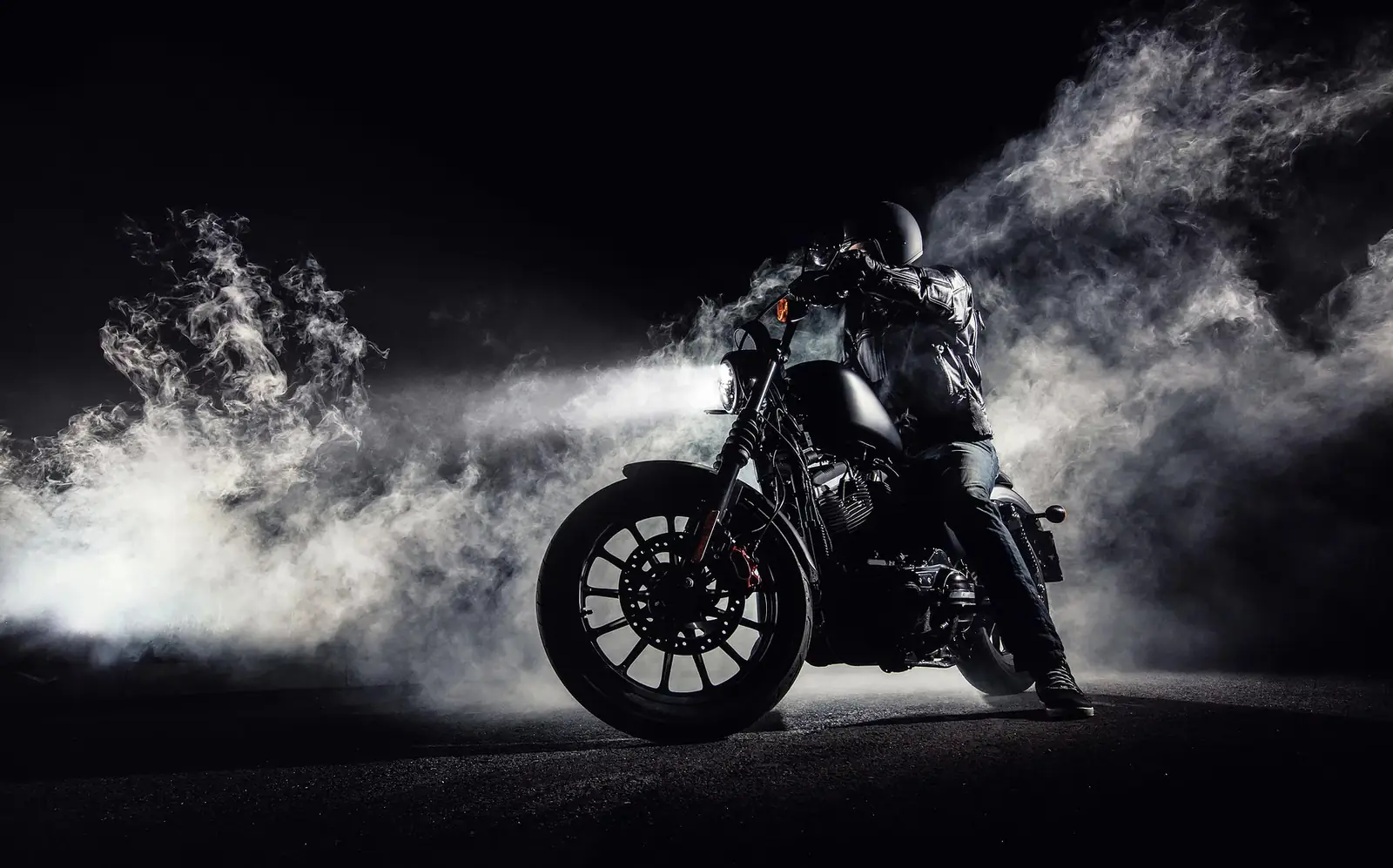 Karanlık zeminde duman içinde motosiklet